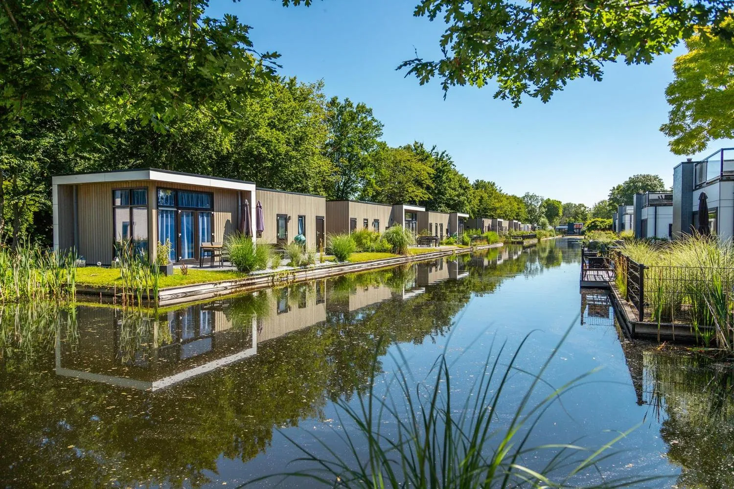 Moderne Ferienhäuser mit Glasfassaden an einem Kanal