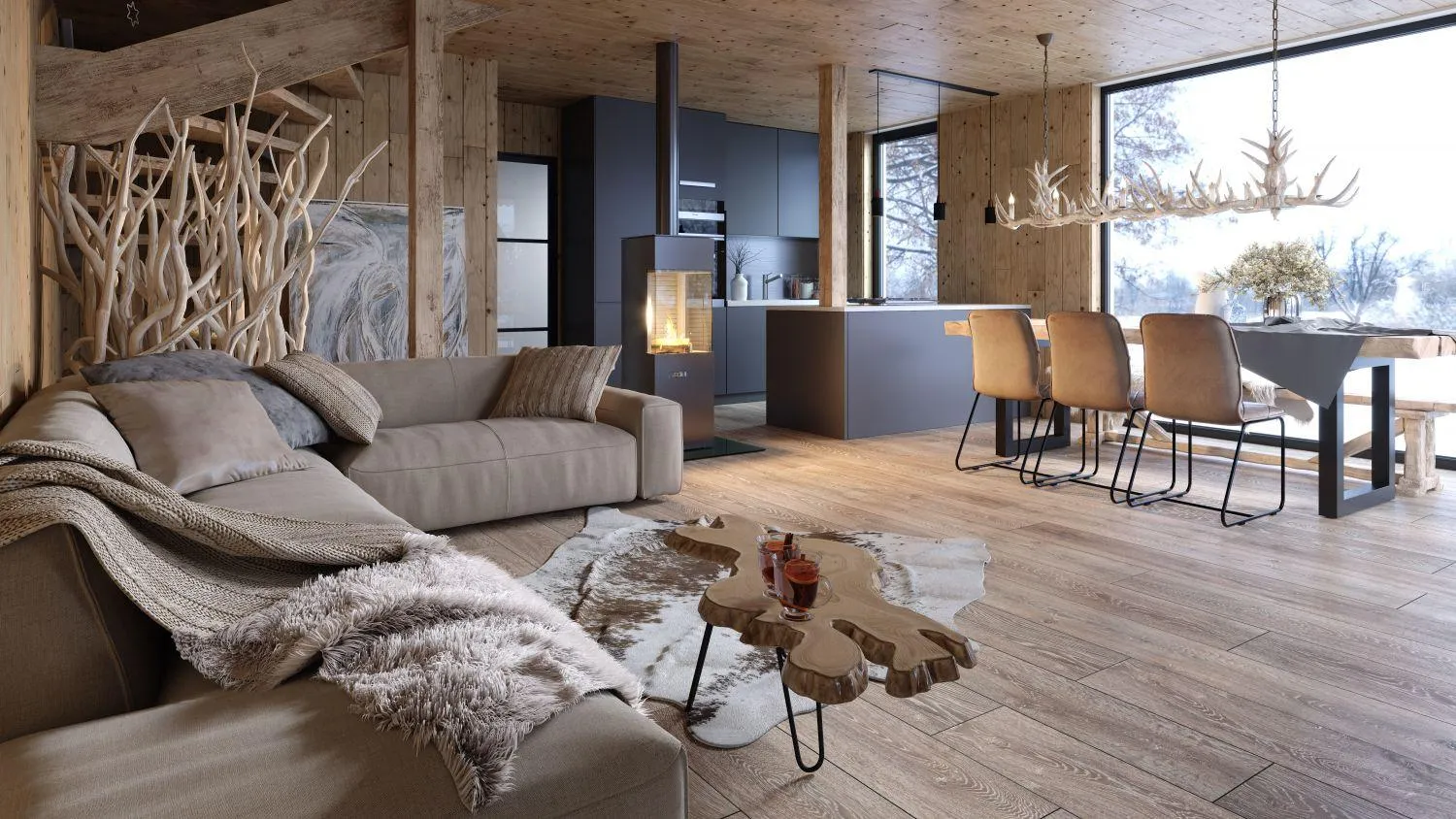 Wohnbereich mit Sofa, Kaminofen und offener Küche im Holzchalet