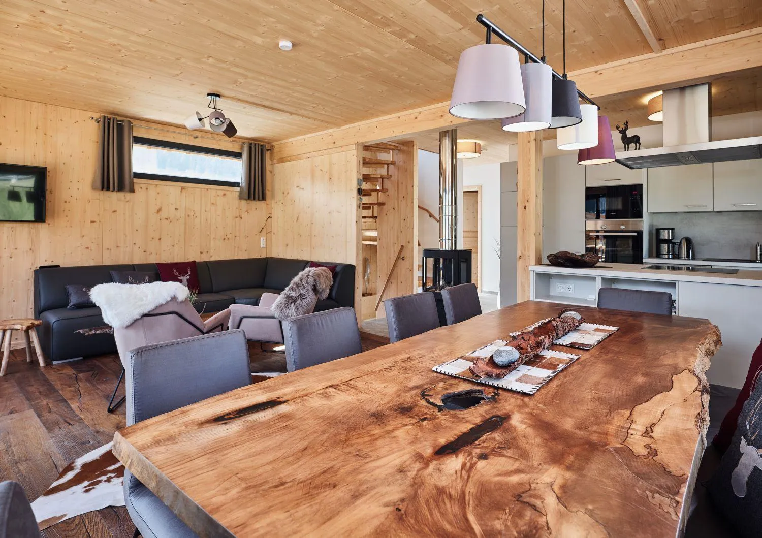 Wohnzimmer mit Baumkanten-Tisch und offener Holzdecke, moderne Ausstattung