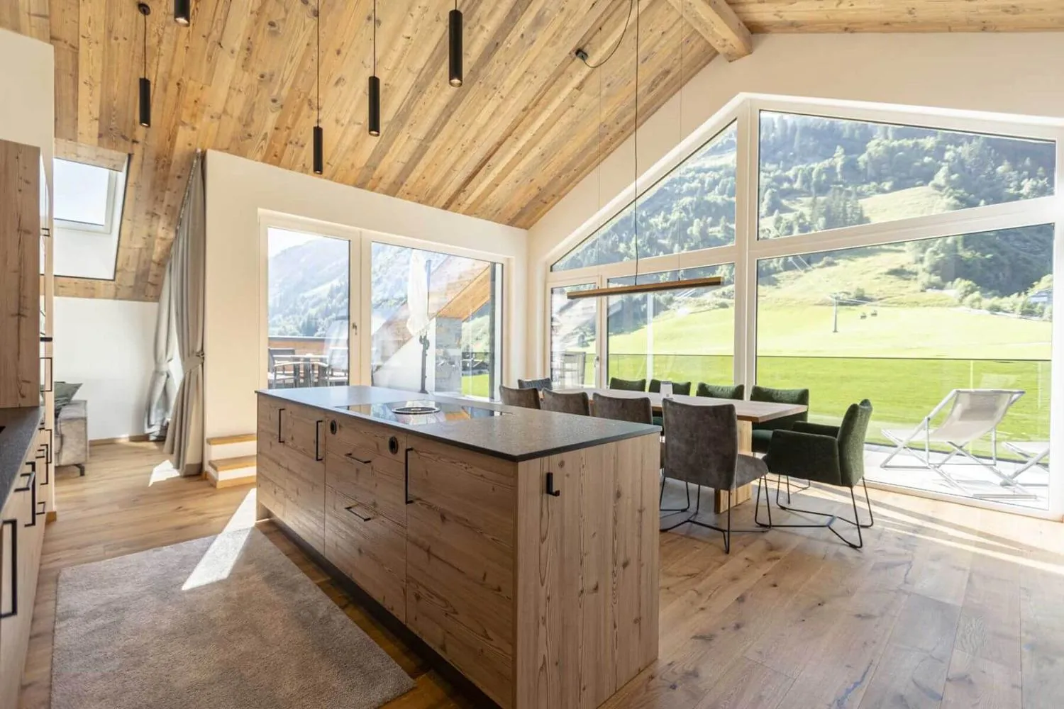 Wohnküche mit Holzdecke, Kochinsel und Panoramafenstern auf Berge