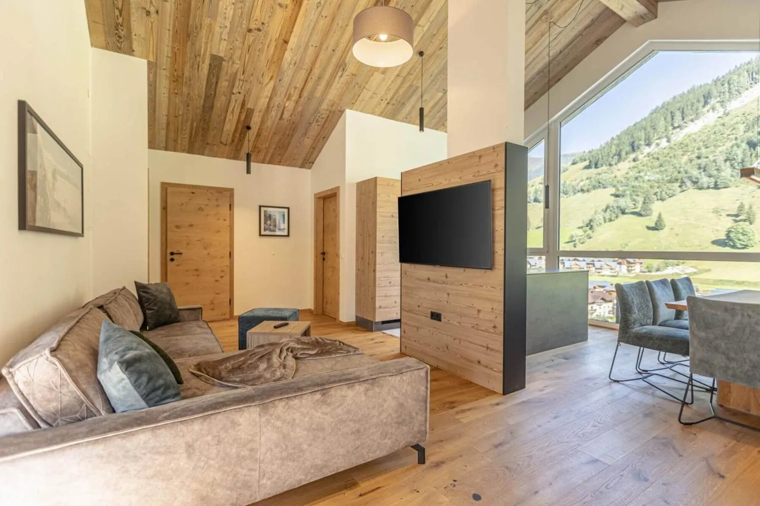 Wohnzimmer mit dunklem Küchenblock und großem Bergfenster