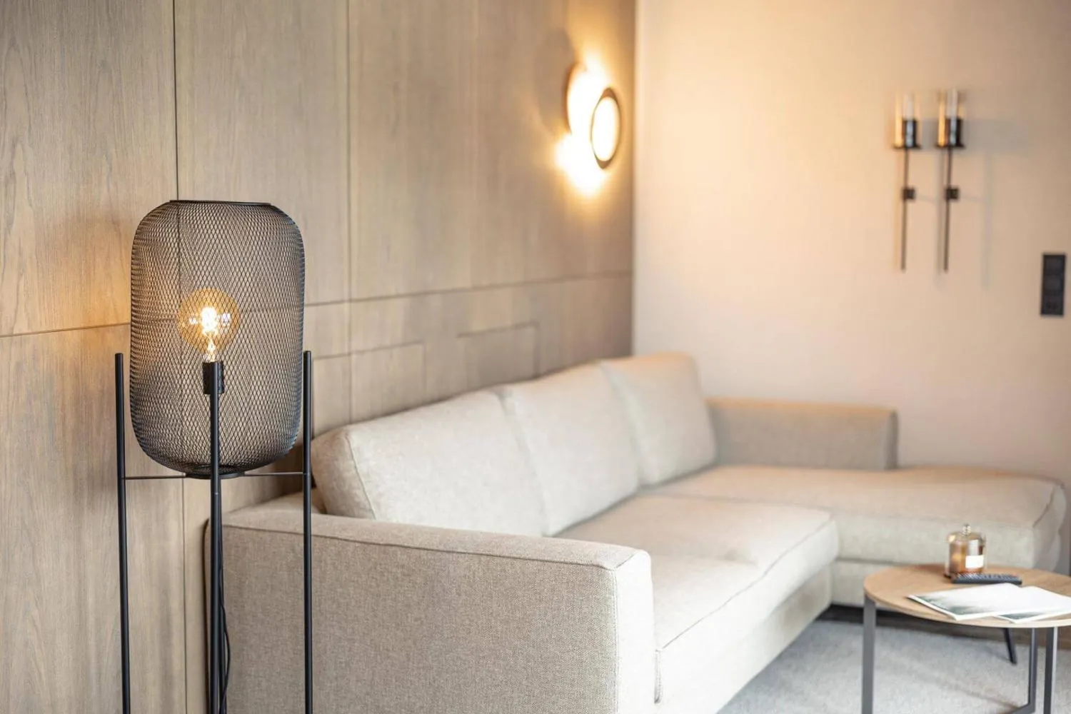 Gemütliches Wohnzimmer mit Polstersessel und moderner Stehleuchte