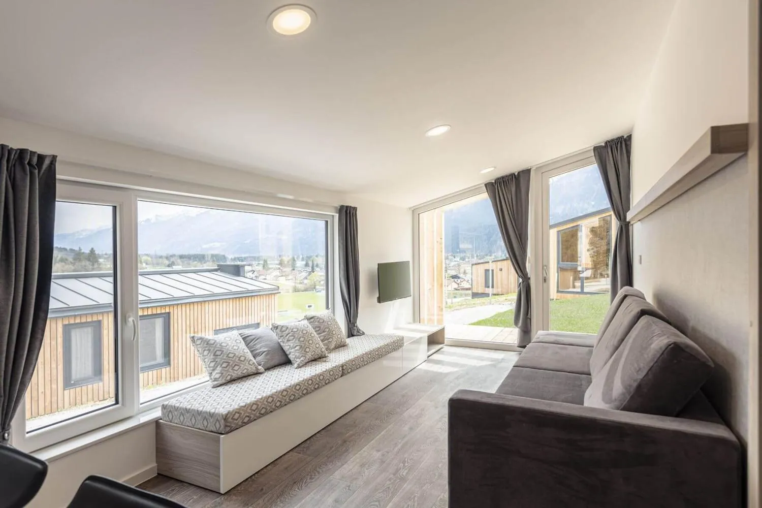 Helles Wohnzimmer mit breiten Fenstern und Bergblick
