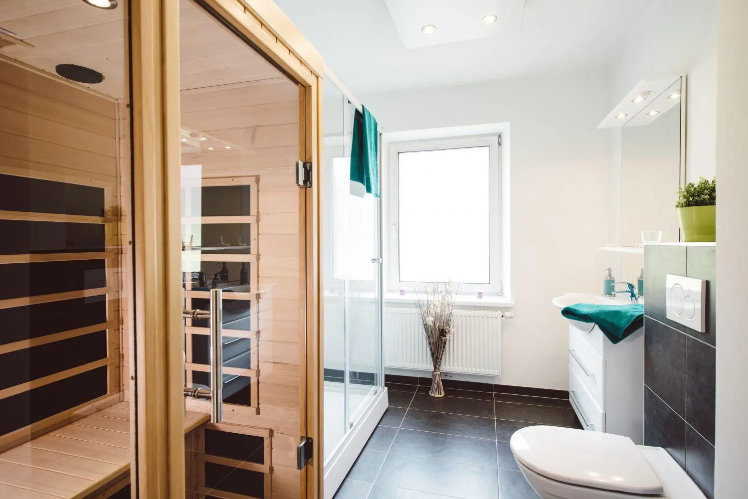 Badezimmer mit Holzsauna, Fenster und modernem Duschbereich