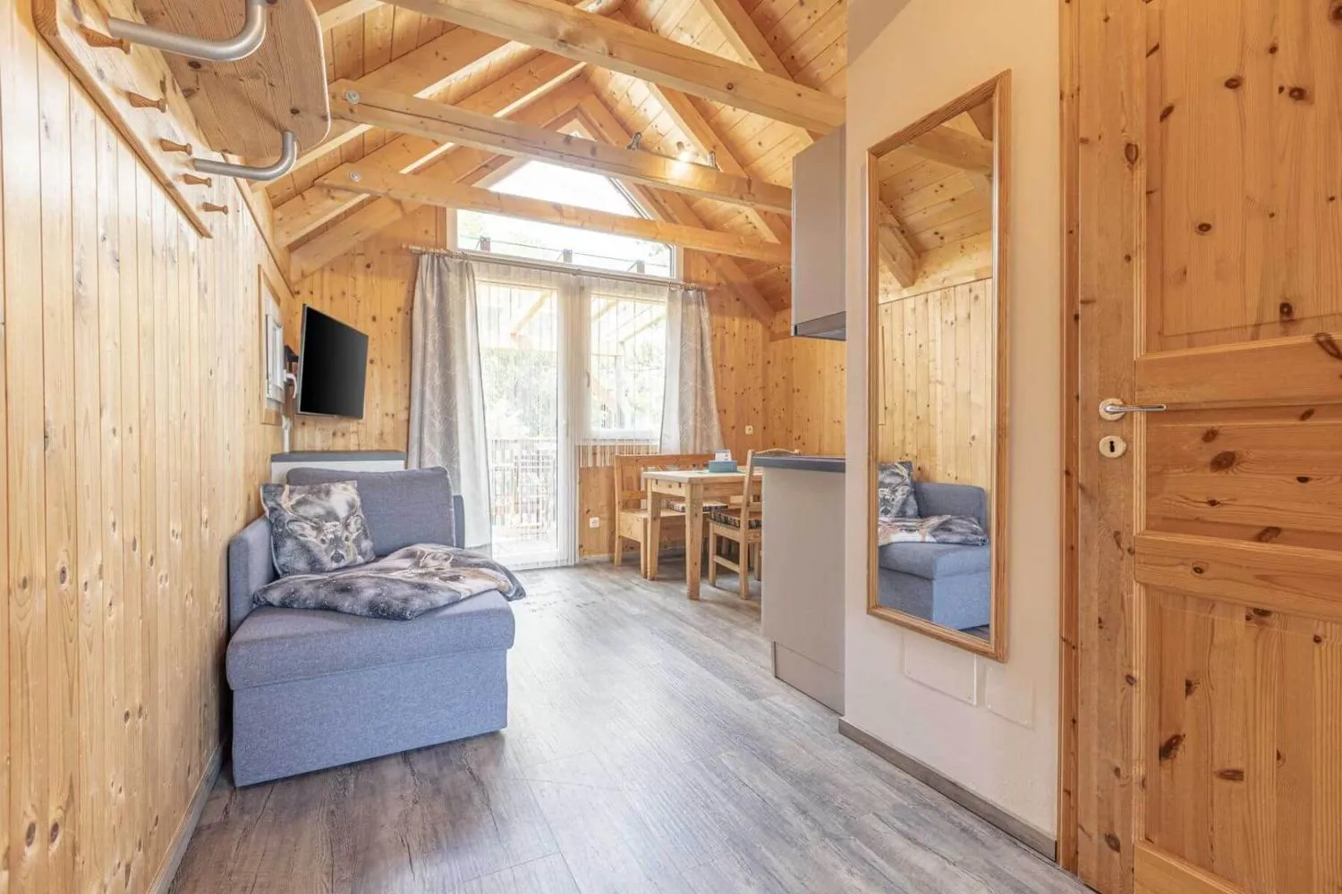 Modernes Wohnzimmer mit TV und Ledersessel im Holzchalet