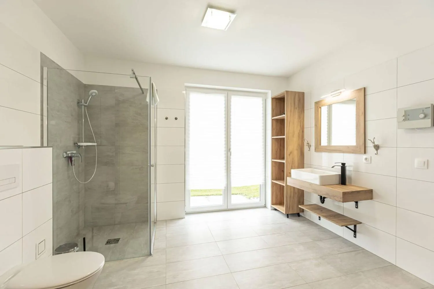 Modernes Badezimmer mit Granitdusche, Holz-Spiegel und Gartentür