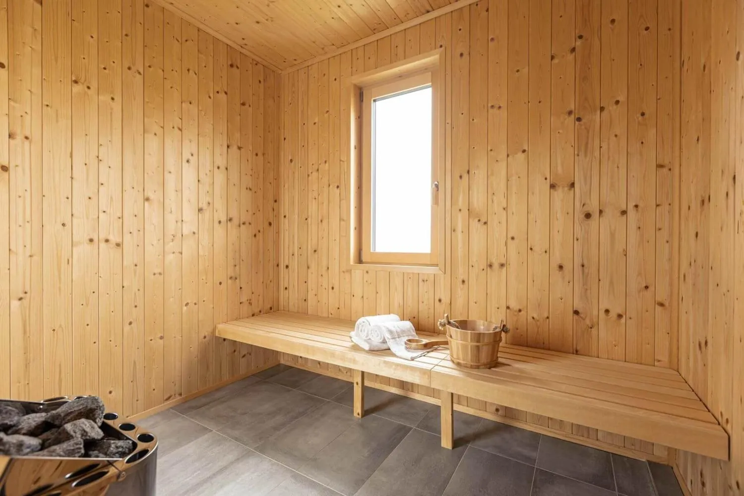 Holz-Sauna mit Bank, Fenster und Badetücher