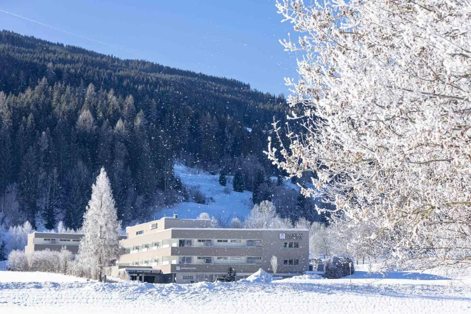 Resort-Gebäude in winterlicher Berglandschaft mit Raureif-Bäumen