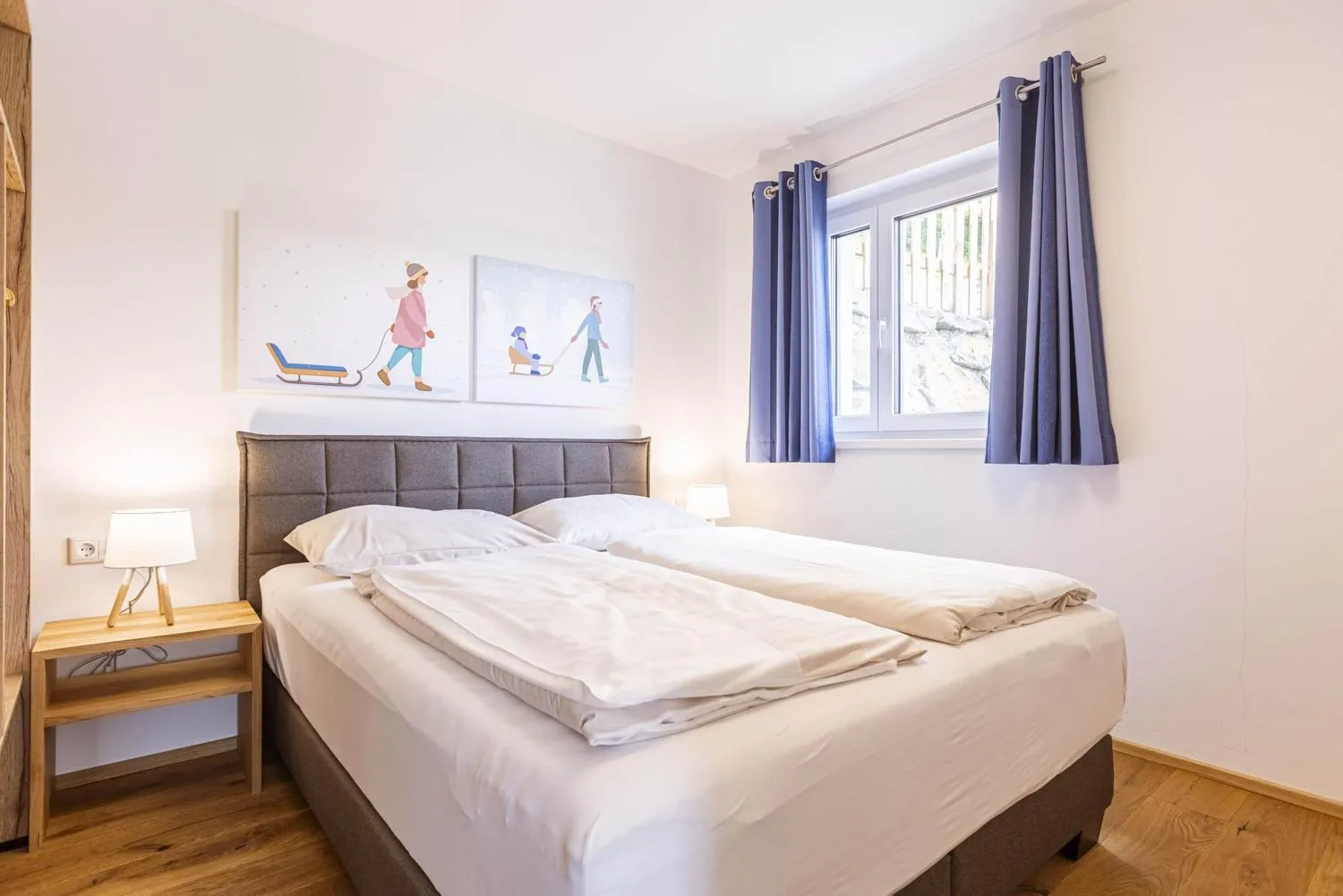 Helles Kinderzimmer mit Doppelbett und Blick auf Balkon und Wald