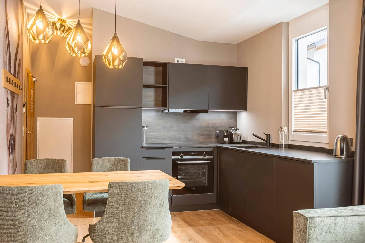 Moderne Küchenzeile mit Essbereich und goldenen Pendelleuchten