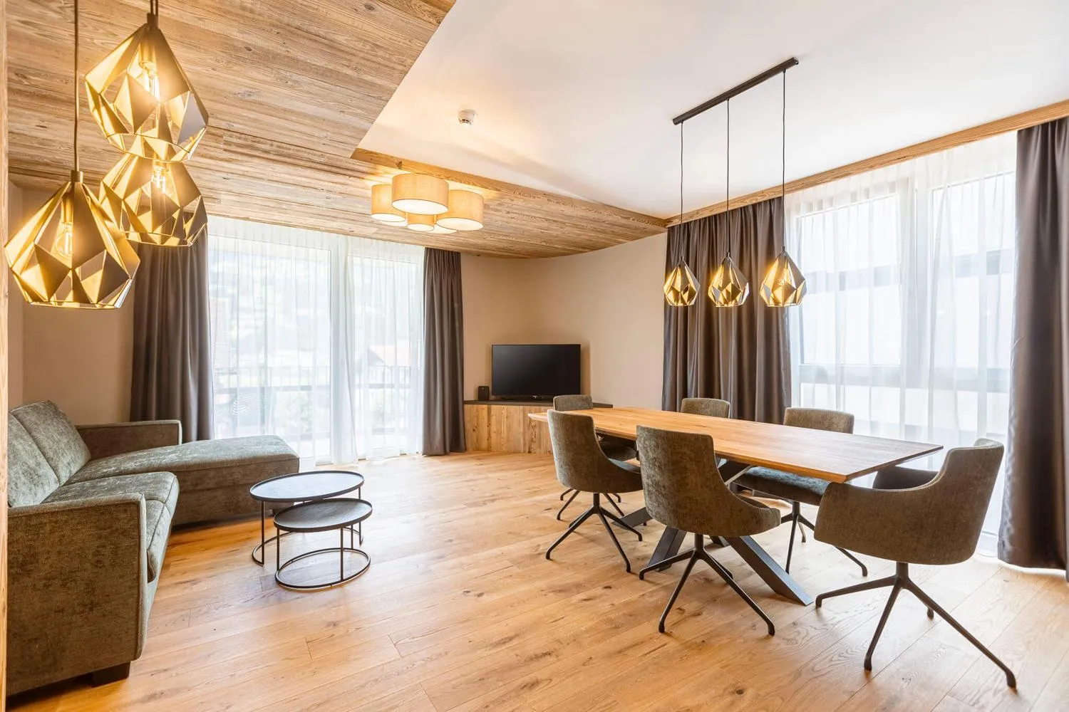 Geräumiges Suite-Wohnzimmer mit Holzdecke und Fensterfront