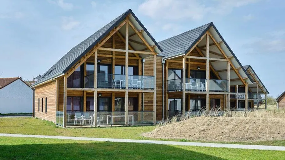 Großes modernes Gebäude mit Holzrahmen und Balkonen am Strand