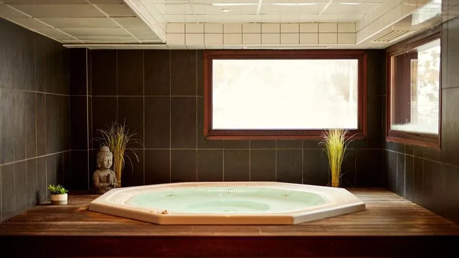 Wellness Bereich mit Whirlpool, Holzausstattung und moderner Beleuchtung