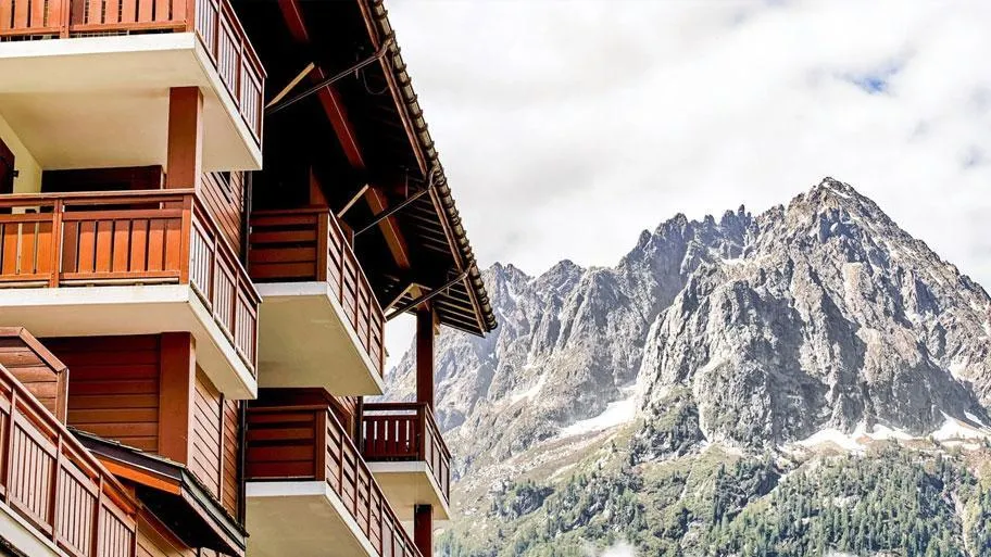 Resort Fassade mit Holzbalkonen und schneebedecktem Berg