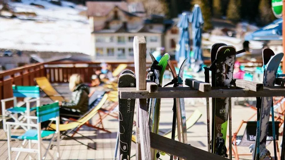 Aufgereihte Skier und Snowboards vor dem Resort