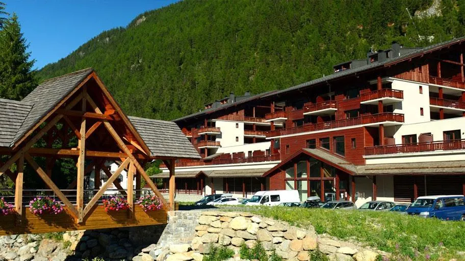 Resort Außenansicht im Sommer mit Holzpavillon und Bergen