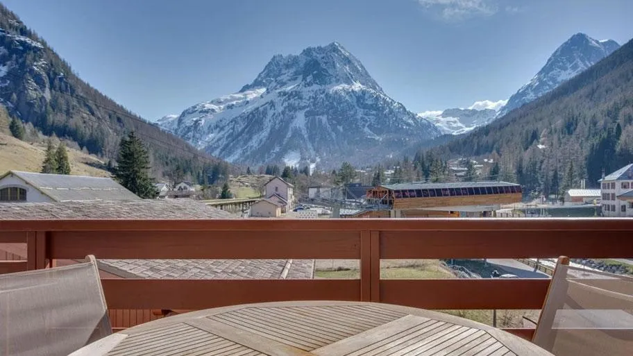 Balkonausblick mit Holzgeländer auf schneebedeckte Berggipfel