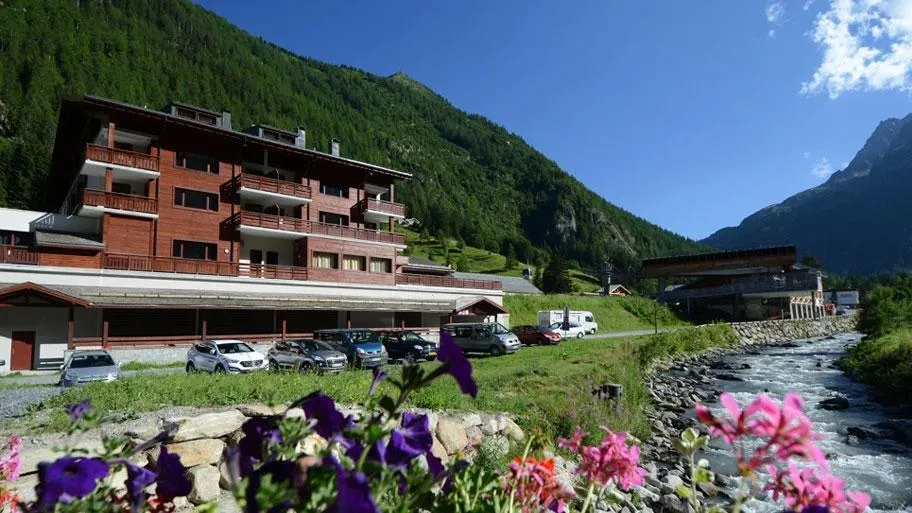 Resort neben Bach mit Blumengarten und Berglandschaft