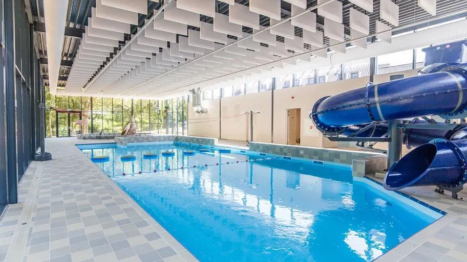 Hallenbad mit Schwimmbahnen und großer Wasserrutsche