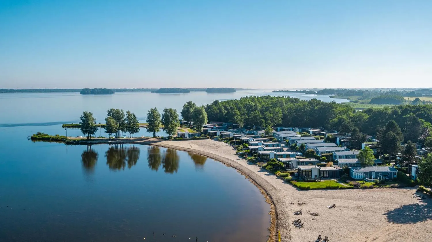 Luftaufnahme eines Ferienpark-Komplexes an einem See mit Marina