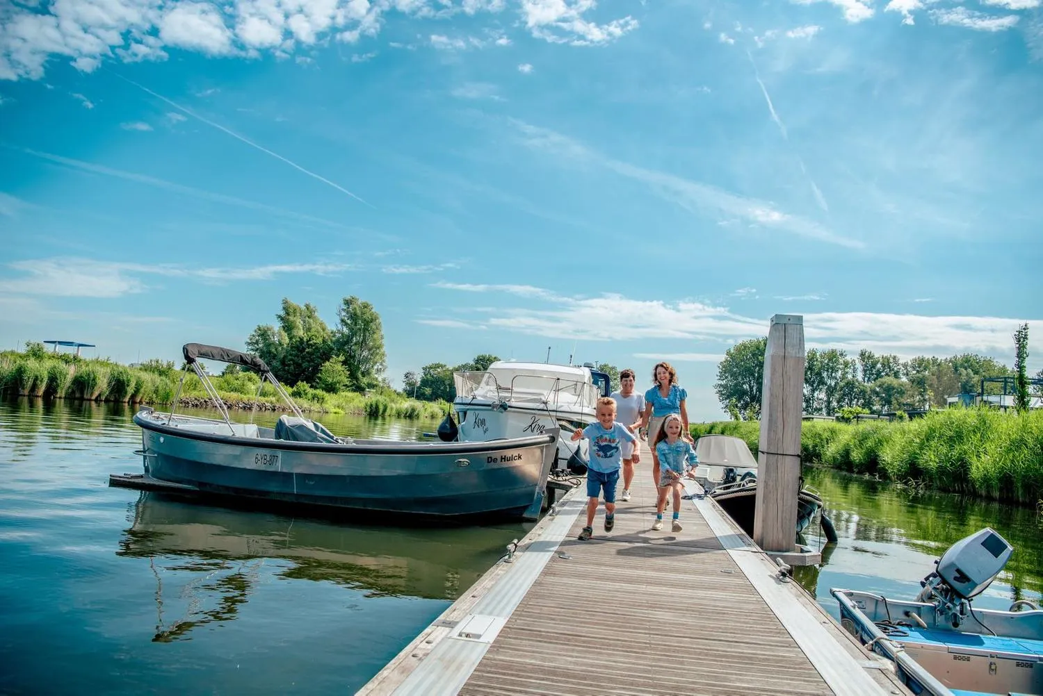 Menschen auf gepflastertem Weg zwischen Ferienhäusern mit Geländer