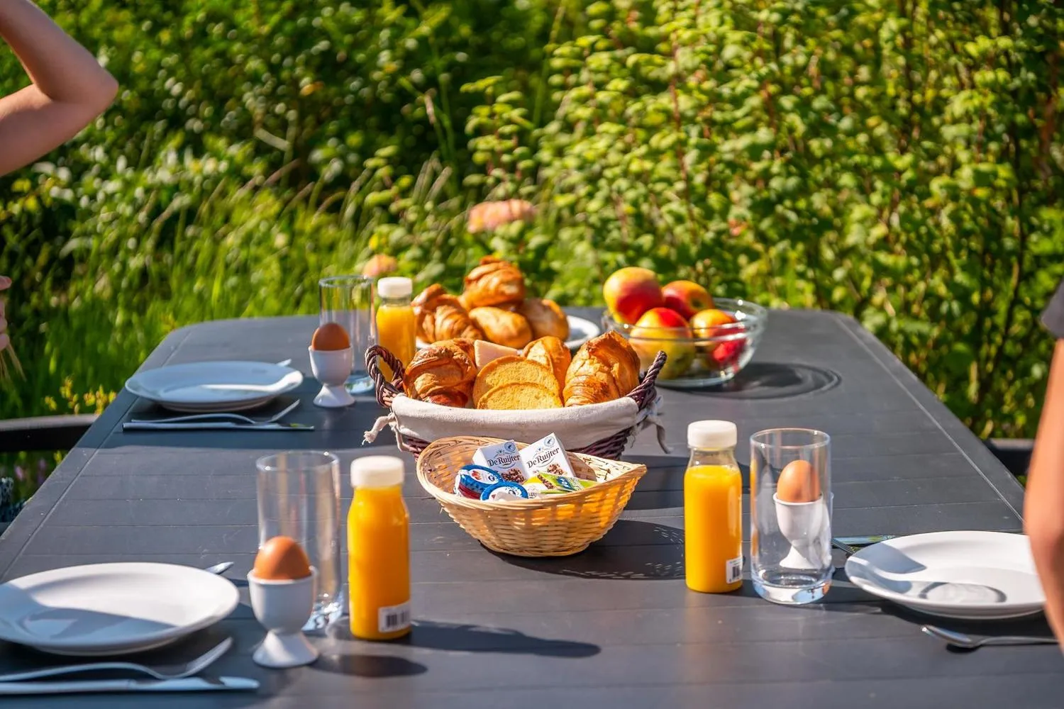 Frühstückstisch mit Croissants, Obst und Orangensaft