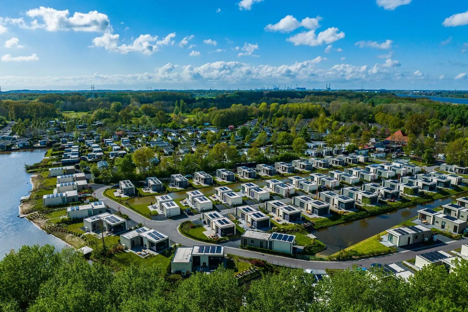 Moderne Häuser mit Solarpanelen am Kanal des Ferienparks