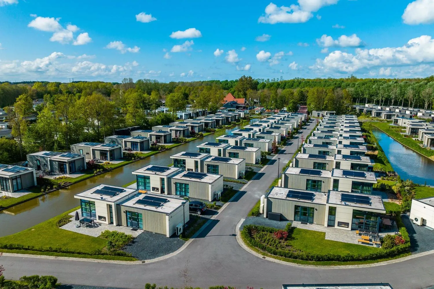 Moderne Häuser mit Solardächern in ordentlicher Anordnung am Kanal