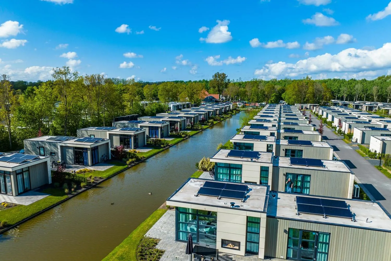 Häuserreihen mit Solarpanelen entlang von Kanälen in grüner Umgebung