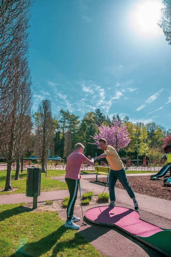 Outdoor-Trainingsanlage unter blühenden Bäumen mit Fitnessgeräten