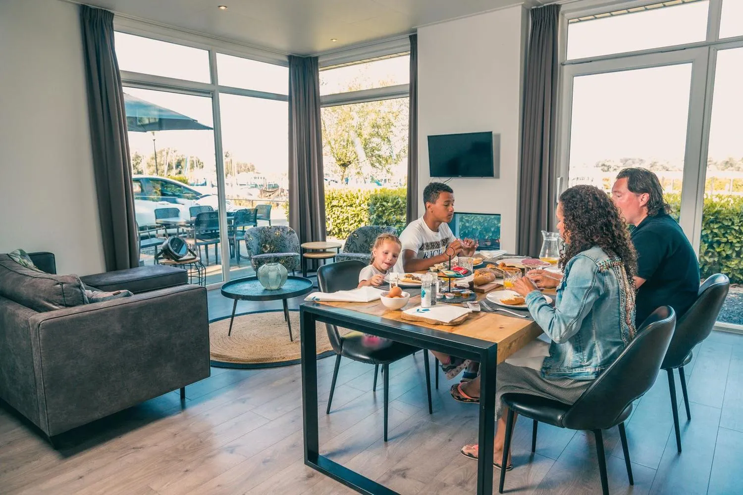 Familie beim Frühstück im modernen Ferienhaus mit Wasserblick