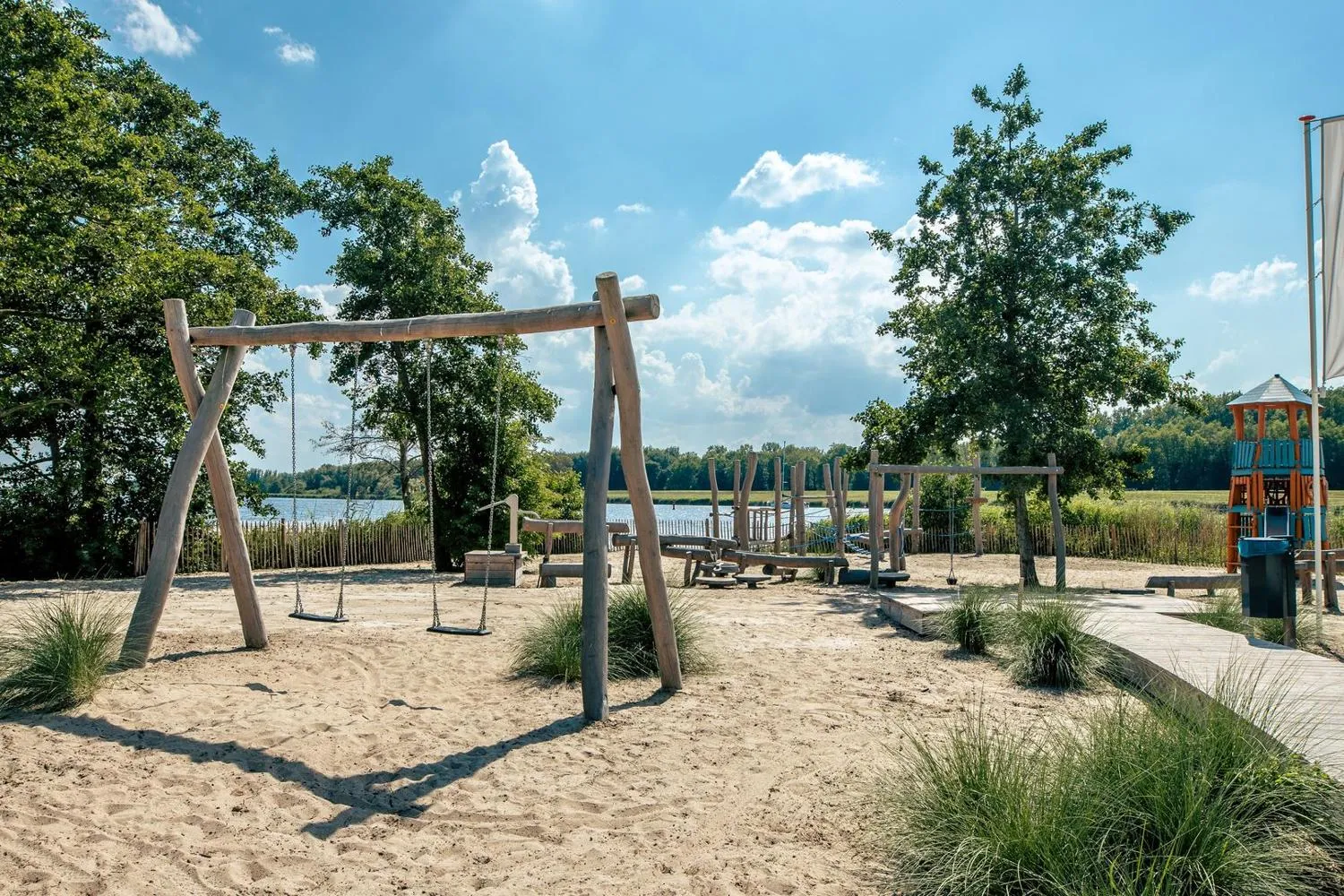 Spielplatz am Seestrand mit Holzschaukeln, Seilschaukel und Spielgeräten
