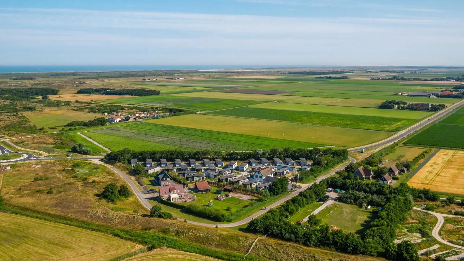 Luftaufnahme des Parks mit blauen Häusern in grüner Feldlandschaft