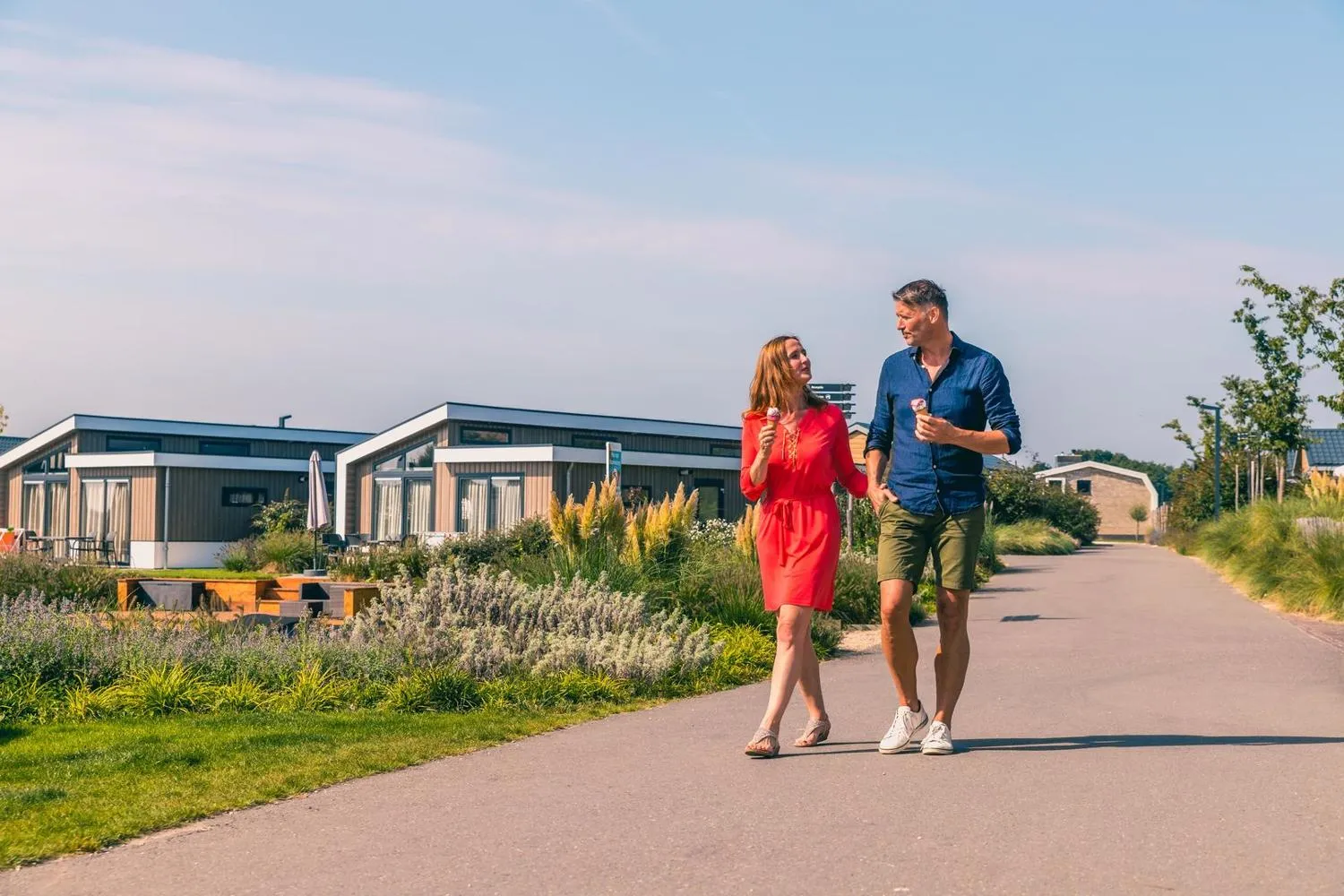 Paar joggt durch den Park zwischen modernen Ferienchalets