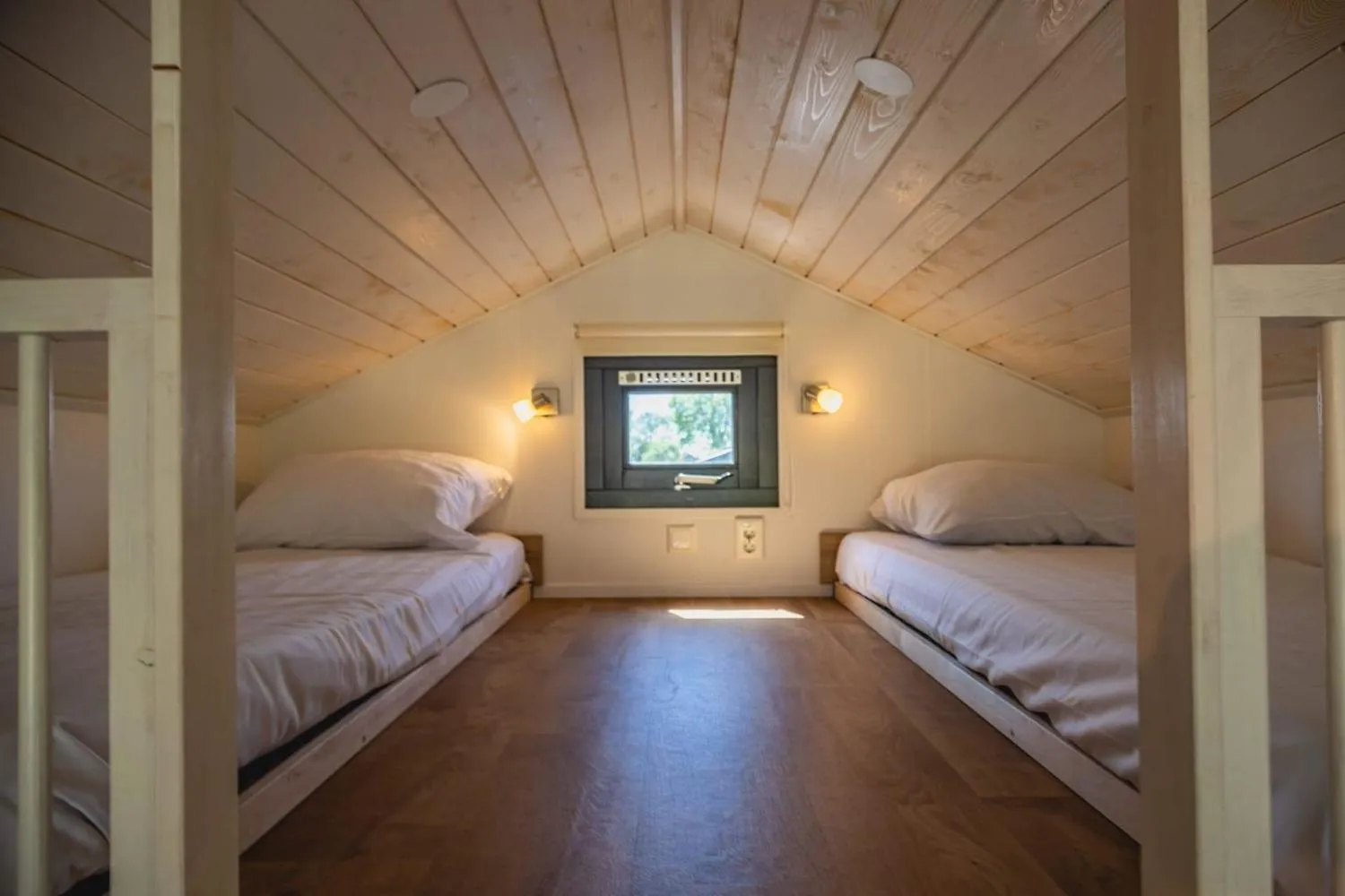 Kinderzimmer mit zwei Einzelbetten und Holzdecke