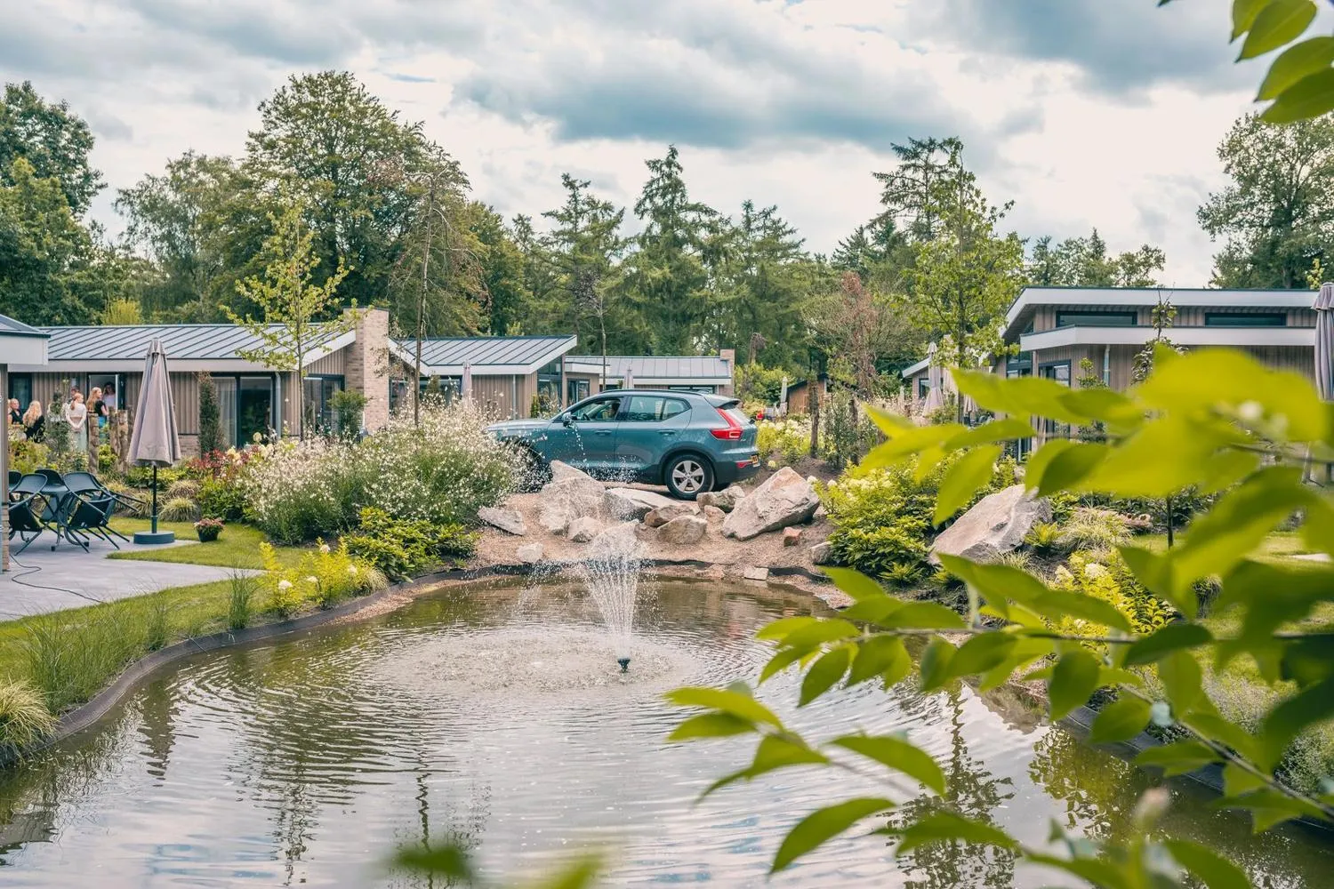 Ferienpark mit Häusern, Auto, Teich mit Springbrunnen