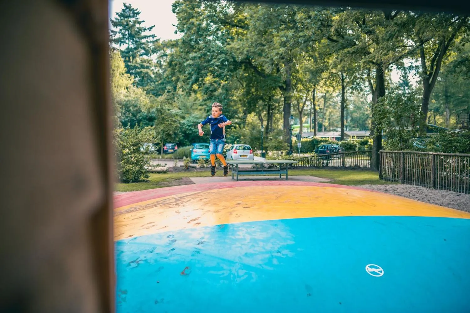 Kind springt auf farbigem Trampolin im Freizeitbereich