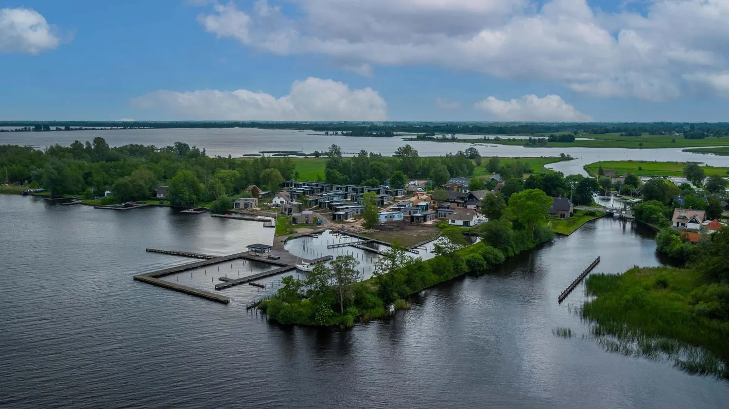 Luftaufnahme des Ferienparks mit modernen Häusern neben Gewässern