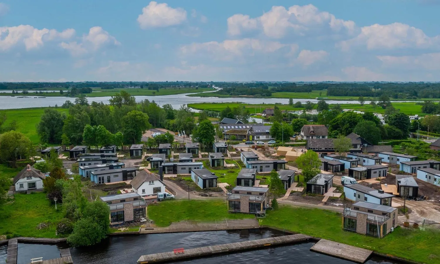 Ferienpark von oben mit Häusergruppen auf Rasen neben Kanälen