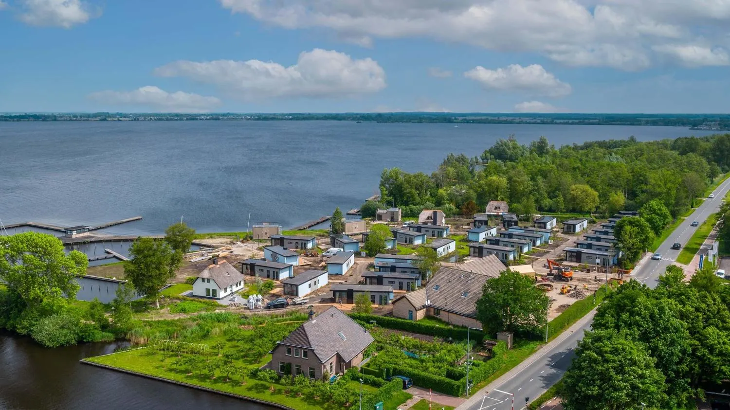 Luftaufnahme mit modernen Ferienhäusern, Rasenflächen und Wasserkanälen