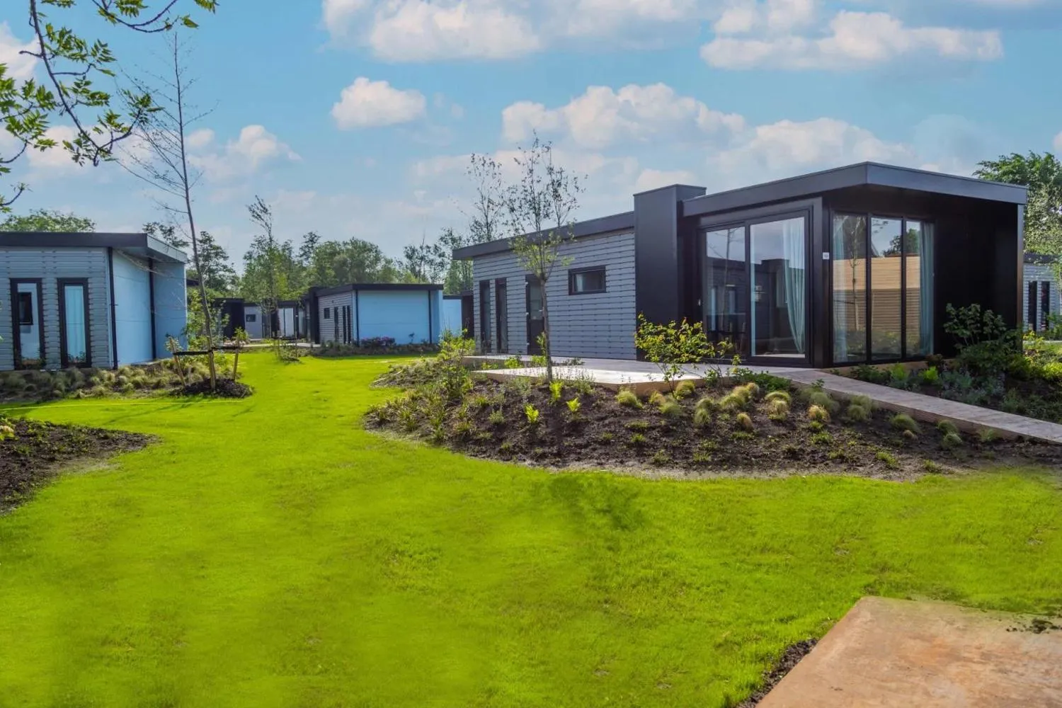 Modernes Ferienhaus mit dunkelgrauer Fassade und Wasserkanal